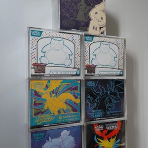 May include: A white ceramic mug with a black handle and the text "But First, Coffee" in a black, handwritten-style font. The mug is on a white surface.