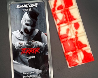 May include: A 50g wax melt in a clear plastic container with a red and white swirl design. The container has a label with a picture of a creepy clown and the text "TERROR Creepy Clown". The label also includes the text "BURNING LIGHTS Burning since 2023 BurningLights.co.uk Pop Culture Inspired Candles".