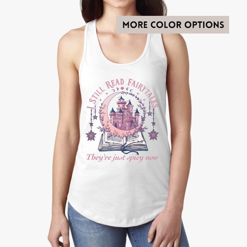 May include: White tank top with a pink and purple illustration of a castle in a crescent moon with stars and the text "I Still Read Fairytales They're Just Spicy Now".