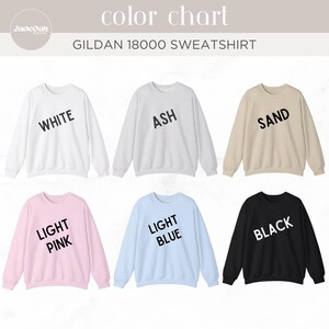 May include: A color chart of Gildan 18000 sweatshirts in various colors, including white, ash, sand, light pink, light blue, and black. Each sweatshirt has the color name printed on it in a bold, sans-serif font.