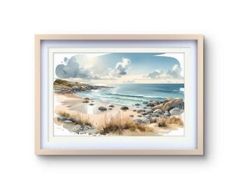 May include: Watercolor painting of a beach scene in a light wood frame. The artwork depicts a sandy beach with rocks, dry grass, and the ocean under a cloudy blue sky. The painting has a soft, natural color palette.
