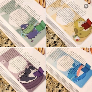 May include: Four different bookmark designs featuring various cartoon characters reading books. The bookmarks are transparent and feature a whimsical design with a speech bubble that says "One of the most important things you will ever learn is that you are worthy of love and belonging."