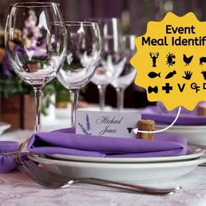 May include: A purple table setting with a white place card that reads "Michael Jones" and a cork with a bull icon on it. The cork is used to identify the meal preference for the guest. A yellow sign with black icons shows the different meal options.