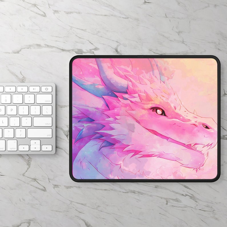 May include: A pink and blue watercolor dragon mousepad with a black border. The dragon has a friendly expression and is looking to the right.