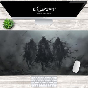 Könnte beinhalten: Rechteckiges Mauspad in Schwarz und Grau mit einer düsteren Fantasy-Illustration von drei vermummten Reitern. Das Mauspad wird von einem Computer, einer Tastatur, einer Maus und einer kleinen Pflanze umgeben. Der Markenname "Eclipsify Custom Designs" ist auf dem Bildschirm zu sehen.