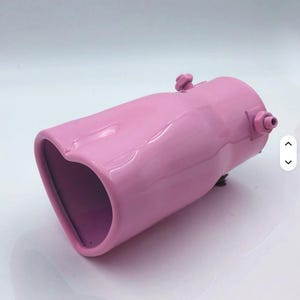 May include: A pink exhaust tip with a heart-shaped opening. The metal tip has a glossy finish and features a cylindrical body with a heart-shaped outlet. It has a bolt and a small nozzle on the side.