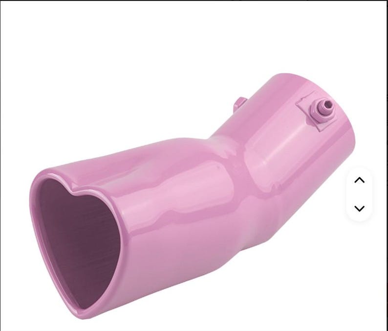 May include: A pink car exhaust tip with a heart-shaped opening. The exhaust tip is angled and has a smooth, glossy finish. It features a small fitting on the side and is designed to enhance the vehicle's appearance.