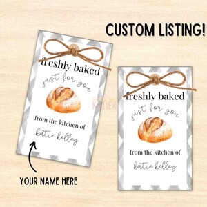 May include: Two white gift tags with a gray and white checkered pattern. The tags have a brown twine bow and feature a watercolor illustration of a loaf of bread. The text on the tags reads "freshly baked just for you from the kitchen of katie kelley". The bottom of the tag says "YOUR NAME HERE".