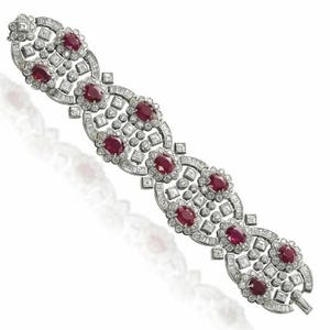 May include: A silver bracelet with a repeating pattern of oval-shaped rubies and diamonds. The bracelet is set in a white metal and has a polished finish.