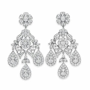 May include: A pair of diamond earrings with a floral design. The earrings feature a large central diamond surrounded by smaller diamonds, and three teardrop-shaped diamond pendants.