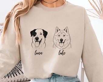 Könnte beinhalten: Beiges Sweatshirt mit zwei Hundeporträts, eines schwarz-weiß, das andere ein Husky. Die Hunde sind mit "Luna" und "Luke" in Schreibschrift beschriftet. Das Sweatshirt hat eine neutrale Farbe.