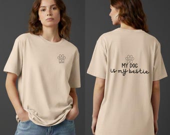 Könnte beinhalten: Beiges T-Shirt mit Pfotenabdruck-Grafik und dem Text "MY DOG is my bestie" auf dem Rücken. Das Shirt hat kurze Ärmel und eine lockere Passform. Die Vorderseite des Shirts ist mit "FRONT" und die Rückseite mit "BACK" beschriftet.