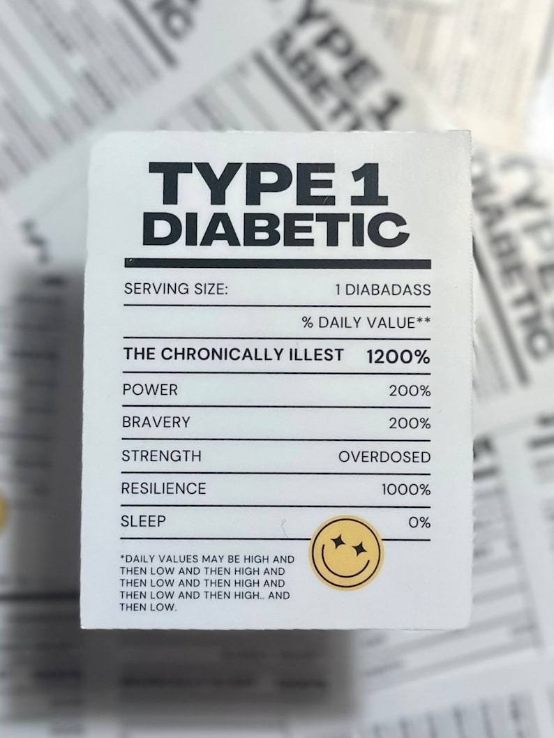 May include: A white card with black text that reads "Type 1 Diabetic". The card lists "Serving Size: 1 Diabass" and "% Daily Value**" with a value of 1200%. The card lists the following categories with their corresponding values: Power 200%, Bravery 200%, Strength Overdosed, Resilience 1000%, Sleep 0%. A yellow smiley face with sparkling eyes is in the bottom right corner.