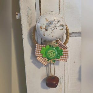 Peut inclure: Une couronne de porte brune et dorée avec un nœud en vichy brun et blanc et un trèfle vert avec le texte "Kiss Me I'm Irish".