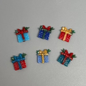 May include: Six small, colorful, gift box ornaments with bows and holly leaves. The ornaments are made of glass and have a textured surface.