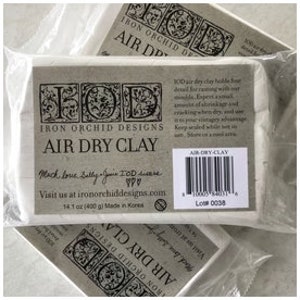 May include: Two packages of Iron Orchid Designs air dry clay, each containing 14.1 ounces (400 grams) of clay. The packages are white with black text and a black and white logo. The text on the package reads "Iron Orchid Designs Air Dry Clay". The packages are made in Korea.