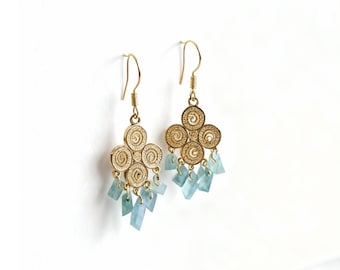 May include: Gold-toned chandelier earrings with a floral design and light blue, rectangular-cut gemstones. The earrings have a hook closure and are displayed against a white background. The earrings are approximately 2 inches long.