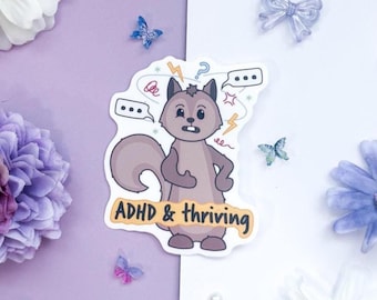 May include: A sticker featuring a cartoon squirrel with the text "ADHD & thriving." The squirrel is light brown with a worried expression, surrounded by thought bubbles, lightning bolts, and question marks. The sticker is on a purple and white background with decorative flowers and butterflies.