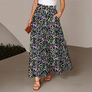 May include: A long, flowing skirt with a black background and a colorful alphabet letter pattern. The skirt has a high waist, pockets, and a drawstring. The letters are in shades of pink, green, yellow, and blue.