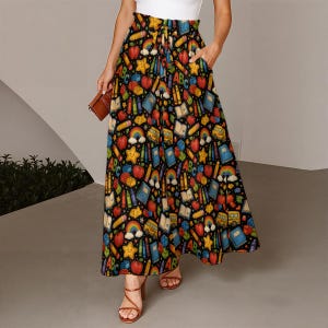 May include: A high-waisted, floor-length skirt with a black background featuring a colorful pattern of school-themed icons including apples, rainbows, yellow stars, pencils, crayons, notebooks, school buses, and the letters ABC.