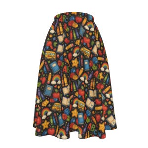 May include: A black A-line skirt featuring a colorful repeating pattern of school-themed illustrations including yellow school buses, red apples, blue notebooks, crayons, rainbows, stars, and the letters ABC scattered across the fabric.