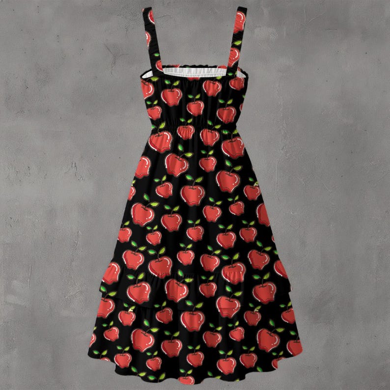 May include: A black sundress with red apple illustrations and green leaves. The dress features a square neckline, thin straps, and a tiered skirt. The apple pattern is repeated across the entire dress.