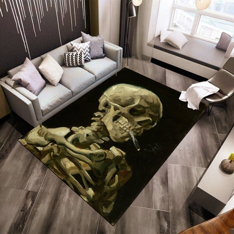 May include: A black and gold area rug with a painting of a skull smoking a cigarette. The skull is in a realistic style and the painting is on a dark background.