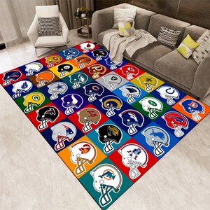 May include: A colorful area rug featuring a grid pattern of American football helmets. Each helmet is set against a vibrant square background, showcasing various team logos and colors. The rug is designed for indoor use.