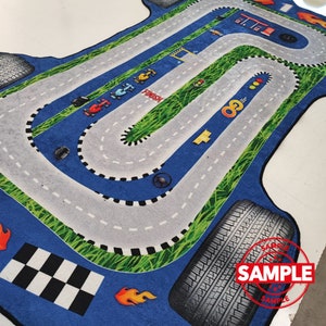 May include: A blue and green race track rug with a checkered finish line, tire tracks, and the word "FINISH" printed on it. The rug is designed to look like a real race track.