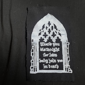 Peut inclure: Écusson en tissu noir avec un motif d'arche gothique blanc et du texte. Le texte se lit comme suit : "Would give distonight for love baby joins me in death". L'écusson a un bord vieilli.