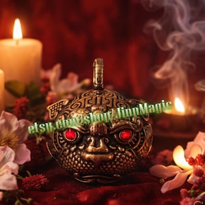 Puede incluir: Quemador de incienso de estilo antiguo y ornamentado con un diseño detallado de rostro de dragón. El quemador es de color dorado con ojos de gemas rojas. Velas encendidas y flores rodean el quemador, creando un ambiente místico.