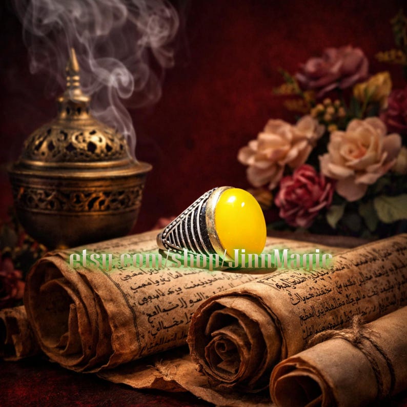 May include: A silver ring with a large, oval, yellow gemstone. The ring is set against a backdrop of antique scrolls, a decorative incense burner, and flowers. The ring's band has a black and silver striped design.