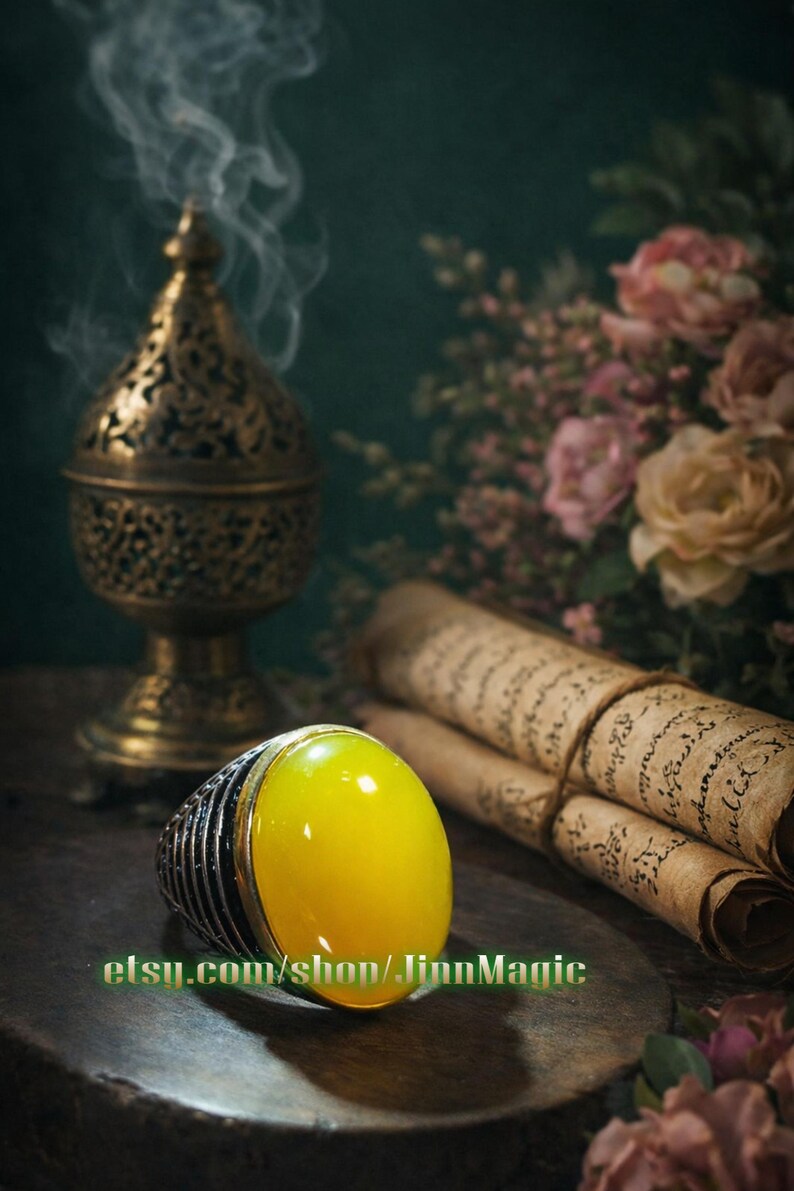 May include: A gold-colored incense burner with smoke rising, a large yellow gemstone ring, and rolled parchment scrolls. The ring has a silver band. The background features flowers and a dark green wall.