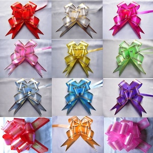 May include: Assortment of 12 pre-tied gift bows in various colours, including red, pink, white, yellow, green, blue, purple, and orange. Each bow has a gold stripe and is made of satin ribbon.
