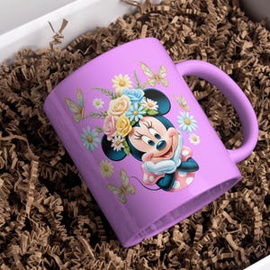 May include: A purple ceramic mug with a floral design featuring a cartoon character with a flower crown. The character is wearing a red and white polka dot dress.