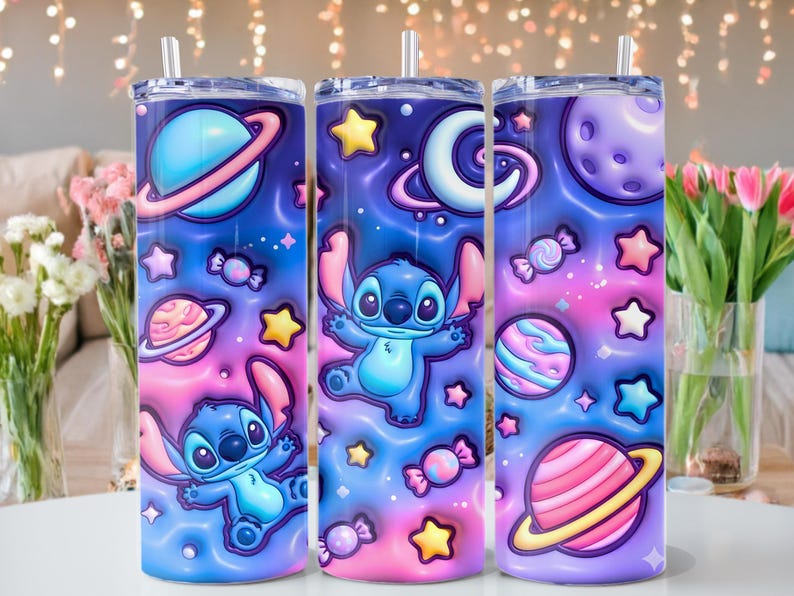 May include: Three stainless steel tumblers with a space-themed design featuring the character Stitch. The tumblers have a blue, pink, and purple gradient background with planets, stars, and candy. Each tumbler has a straw.