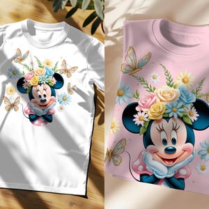 May include: Two t-shirts featuring a cartoon image of Minnie Mouse wearing a flower crown. The white t-shirt has a simple design, while the pink t-shirt has a more detailed floral pattern.