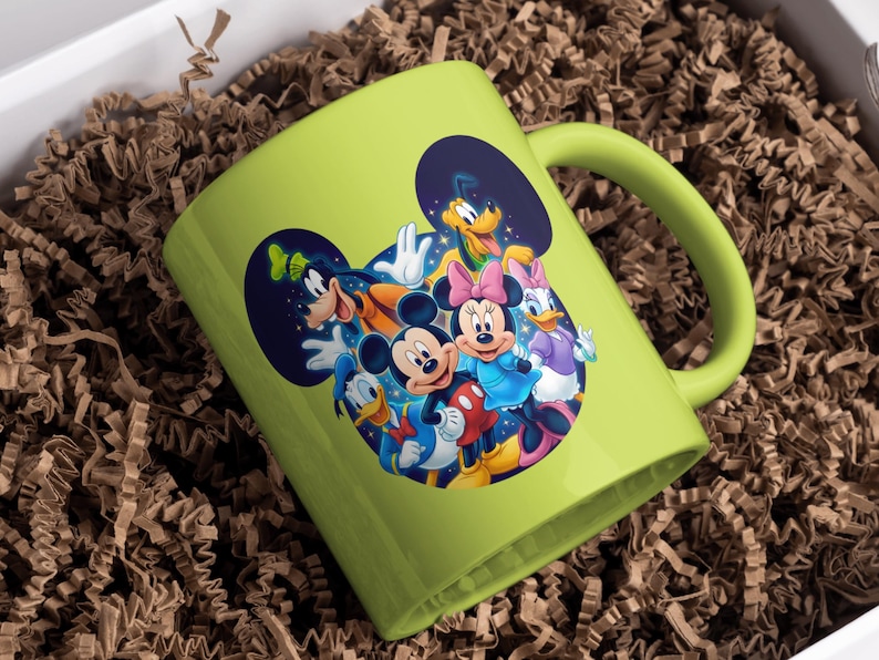 May include: A lime green ceramic mug featuring a colorful graphic of Mickey Mouse, Minnie Mouse, Donald Duck, Daisy Duck, Goofy, and Pluto. The mug is inside a white box with brown paper filler.