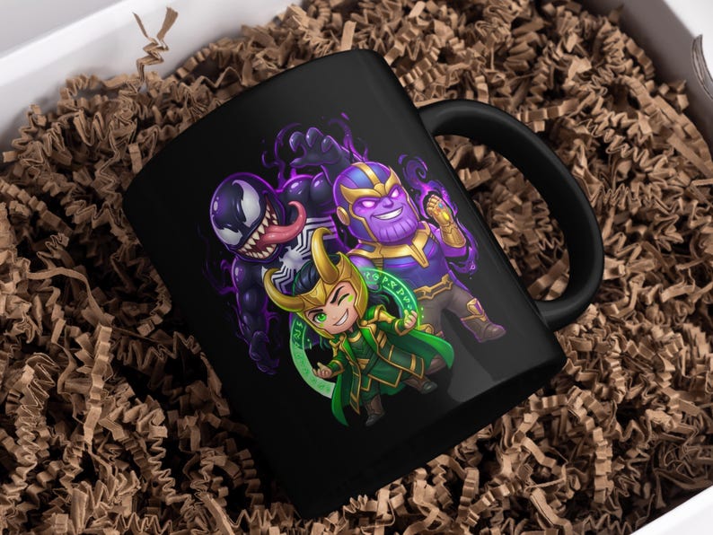 May include: Black ceramic mug featuring cartoon illustrations of Venom, Thanos, and Loki. The characters are depicted in vibrant colors against a black background. The mug is placed in a white box with brown packing material.