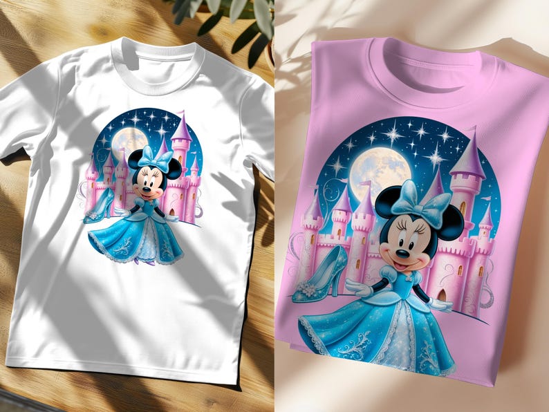 May include: Two t-shirts featuring a cartoon image of Minnie Mouse dressed as a princess in front of a pink castle. The image is set against a blue night sky with stars and a moon. One t-shirt is white and the other is pink.