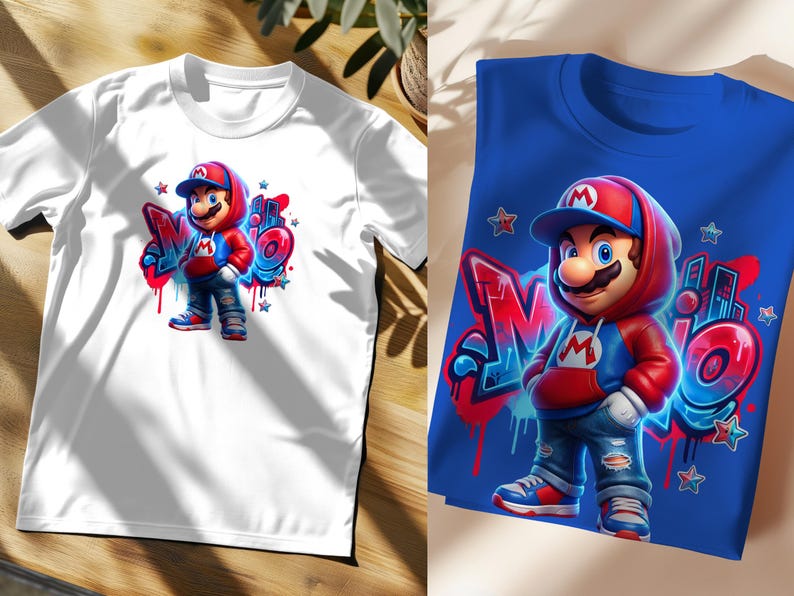 May include: White t-shirt featuring a colorful graphic of a cartoon character in a red and blue outfit, with the word "Mario" in graffiti style. The character is wearing a red cap and hoodie. A second blue t-shirt with the same design is also shown.
