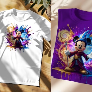 May include: White and purple t-shirts featuring a cartoon illustration of Mickey Mouse dressed as a wizard. The design includes colourful paint splatters, a magic staff, and mystical symbols. The shirts are short-sleeved.