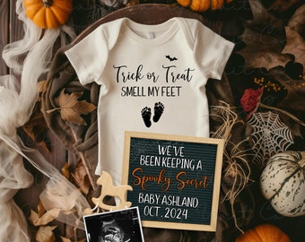 May include: A Halloween-themed baby announcement featuring a cream-colored onesie with "Trick or Treat SMELL MY FEET" text and footprints. A letter board announces "We've been keeping a Spooky Secret BABY ASHLAND OCT. 2024". Pumpkins and fall foliage complete the scene.