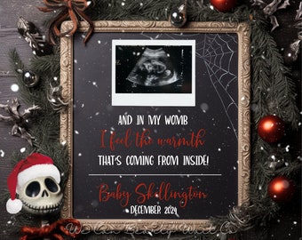 Op de afbeelding: Een zwart schoolbord met een wit frame, versierd met een kerstthema. Het schoolbord heeft een zwart-witte echografie afbeelding en de tekst "AND IN MY WOMB I feel the warmth THAT'S COMING FROM INSIDE! Baby Stillington DECEMBER 2024".