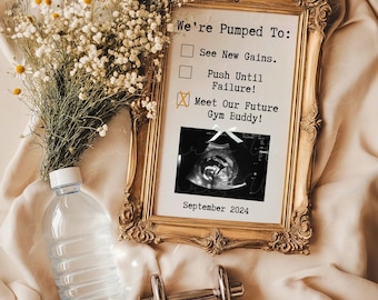 May include: A gold-framed picture with a white background and black text that reads "We're Pumped To:" with a checklist of three items. The first two items are checked off with a black square. The third item is checked off with a yellow X. The third item reads "Meet Our Future Gym Buddy!" An ultrasound image is below the checklist. The date "September 2024" is printed below the image.