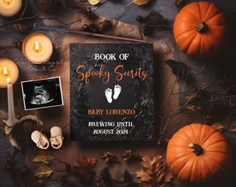 May include: A black book with the text "Book of Spooky Secrets" and "Baby Lorenzo Brewing Until August 2024". The book is surrounded by fall leaves, pumpkins, and candles.