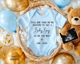 May include: A blue baby onesie with the text "This new year we're excited to say a Baby Boy is on the way! Jan. 2025" surrounded by gold and blue balloons, a teddy bear, and a sonogram image.