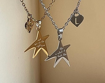 May include: Two gold necklaces with star pendants. The star pendants have engraved text: "met you at the right time" and "this is what it feels like". One necklace has a small heart charm with the letter "L" engraved on it.