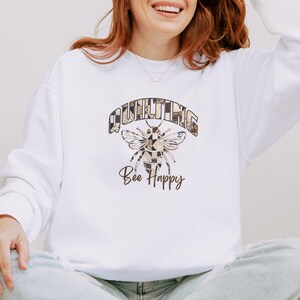 May include: White sweatshirt with a brown graphic of a bee with patchwork wings and the text "QUILTING Bee Happy".