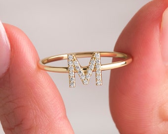 May include: A gold ring with a diamond-encrusted letter M.